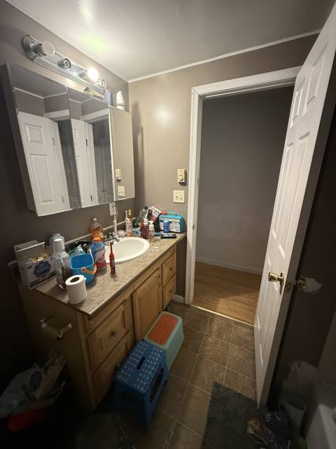 Before: vanity with a long mirror and a door to the hall